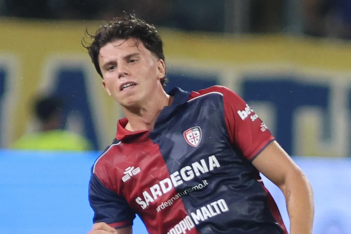 Romano in maglia Cagliari durante la partita, con logo dello stemma e sponsor visibili