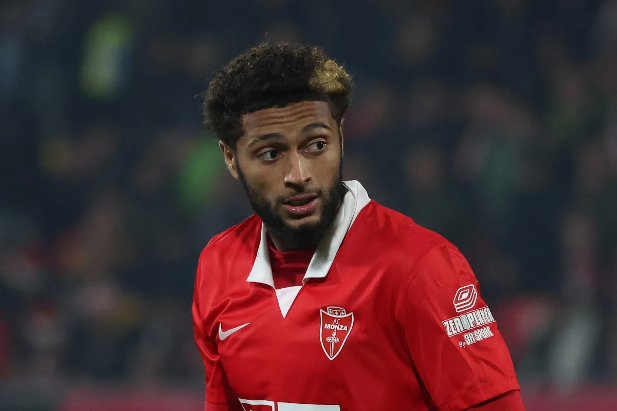 Calciatore con maglia rossa dell'AC Monza con sponsor Nike e ZeroPlayer, sguardo laterale durante una partita